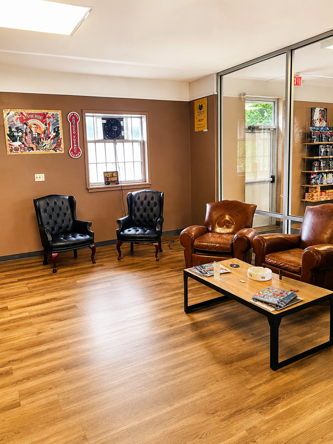 Relax in the comfortable cigar lounge at CigarBox Tamaqua, featuring cozy leather seating and a welcoming atmosphere for cigar enthusiasts. The inviting retail space offers a premium shopping experience with quality cigars and accessories in a clean, well-maintained environment.