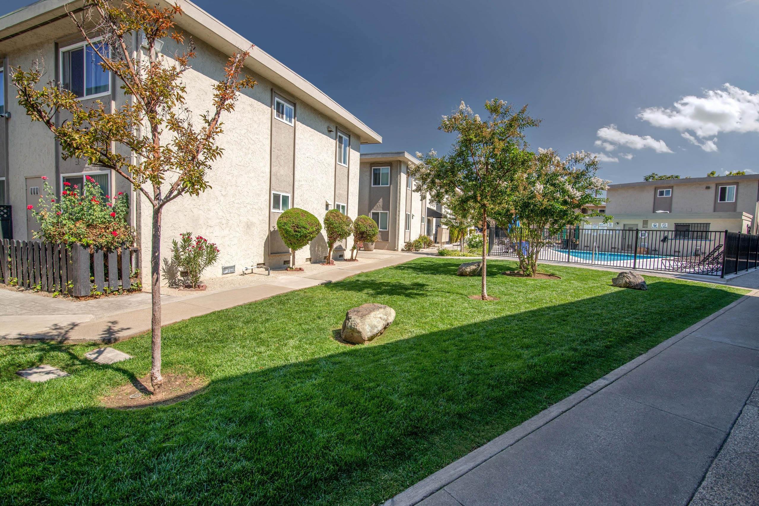 Monterey Manor Courtyard with grass and trees in between the apartment buildings