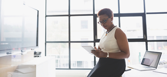 Professional woman on a tablet in her office.