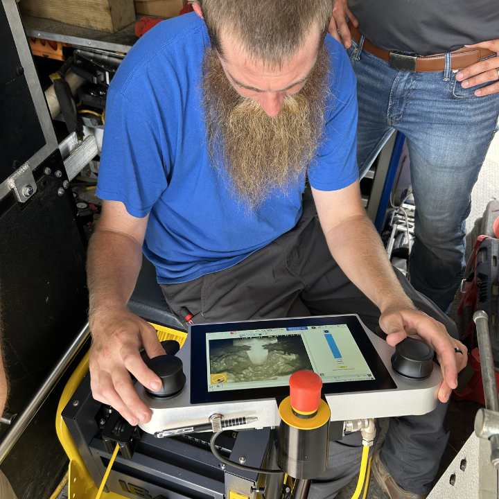 A Hydromax Services technician operates sewer inspection camera controls in the field, guiding advanced equipment through underground lines. Our municipal capabilities include main line inspection, lateral launch camera systems, and smoke testing.