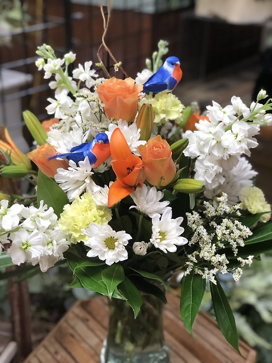 There's nothing like a Sweet Tweet to brighten someone's day! You don't need a reason to buy flowers for that special someone! Send them a Just Because Arrangement today!! Arrangement is filled with orange Lilies, Roses, white Stock, Daisies, and green Carnations. Color of birds may vary.