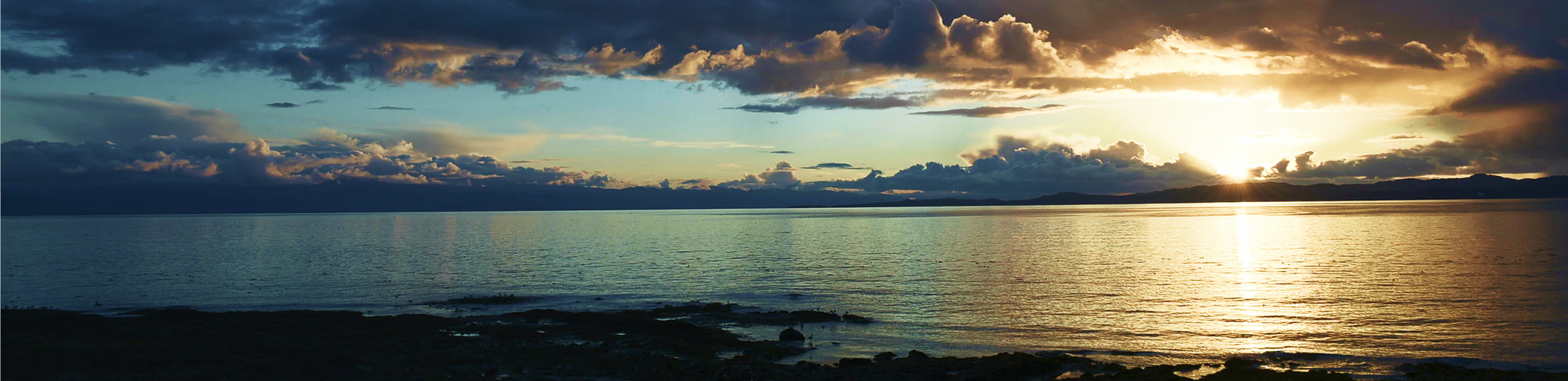 Sunrise over a lake on a partly cloudy morning.