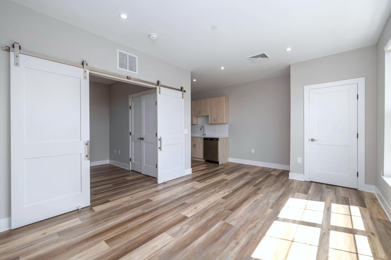 A modern, open-concept living area at Creekline at Fairfield features stylish wood-plank flooring and clean architectural lines.