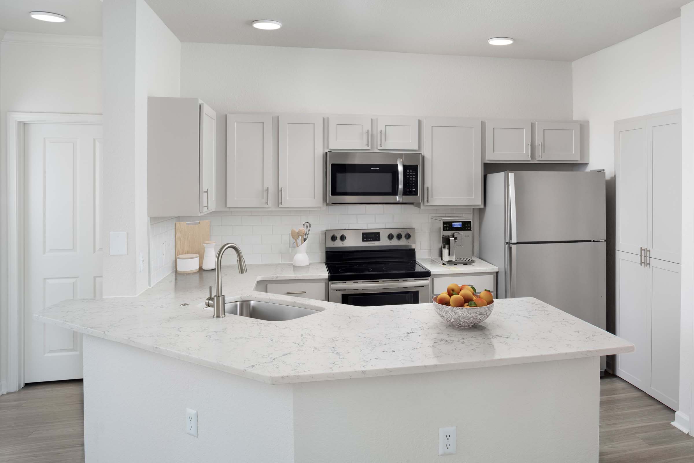 Camden Visconti apartments ktichen with grey cabinetry, quartz countertops and stainless steel appliances in Brandon, FL.