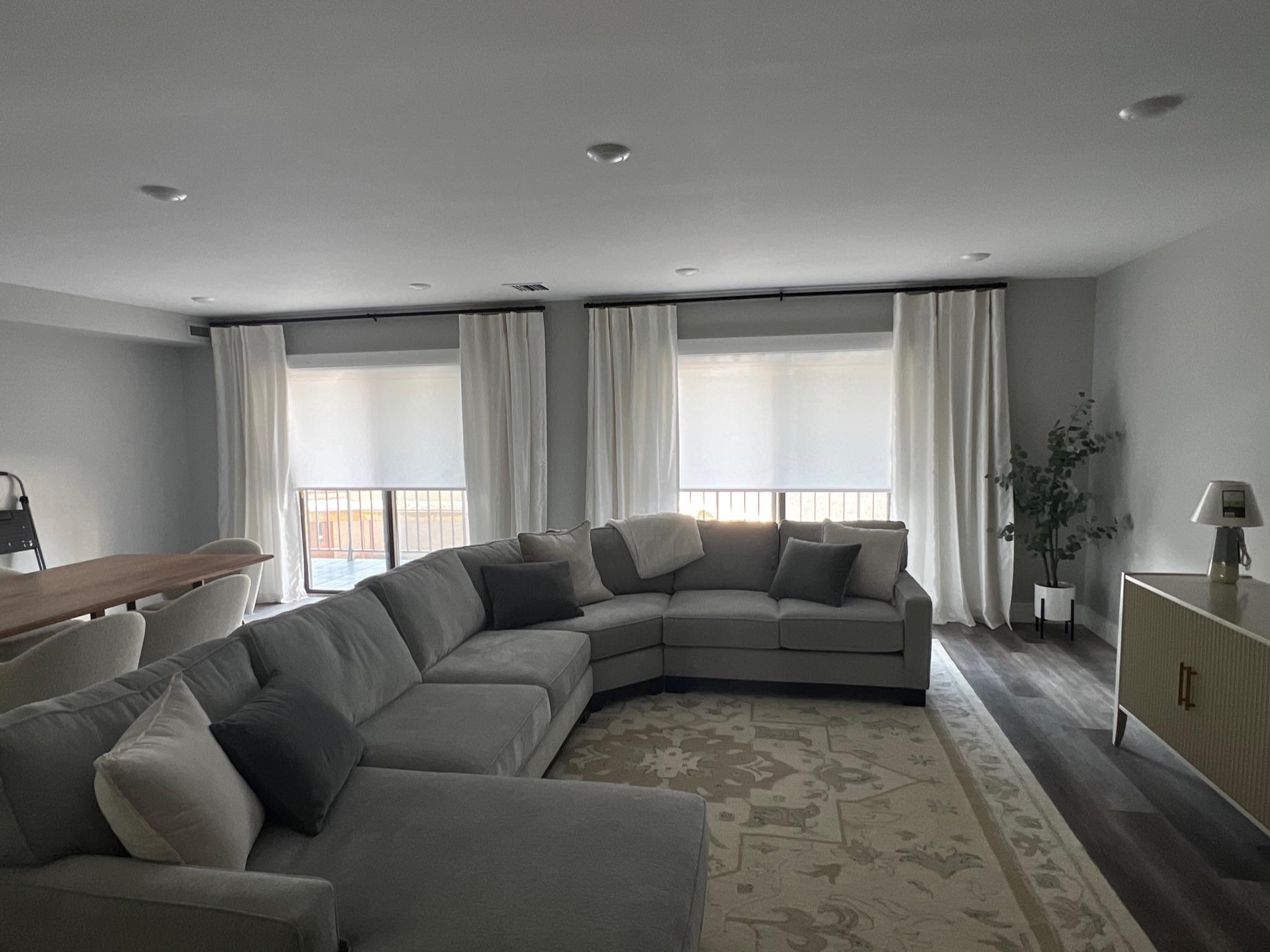 Amazing light filtration for your King of Prussia, PA living room with Lutron roller shades, seen here with matte black hardware and decorative side panels.