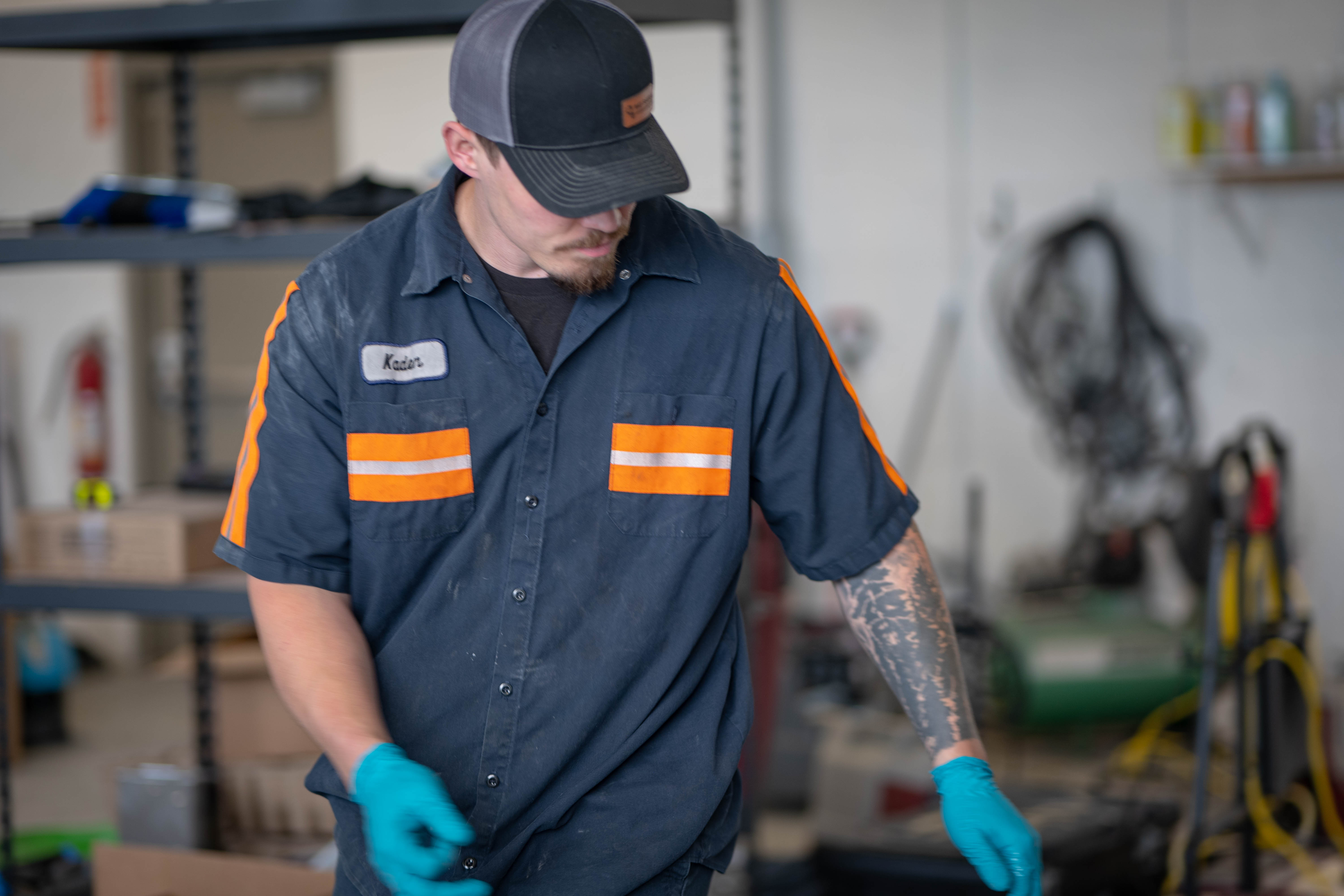 A WaySolutions mechanic gets close to the floor to visually inspect the lower brush deck and chassis of a teal commercial floor scrubber. Operating out of Layton, Utah, we perform deep undercarriage inspections to guarantee streak-free cleaning performance and resolve hidden mechanical wear for industrial facilities.