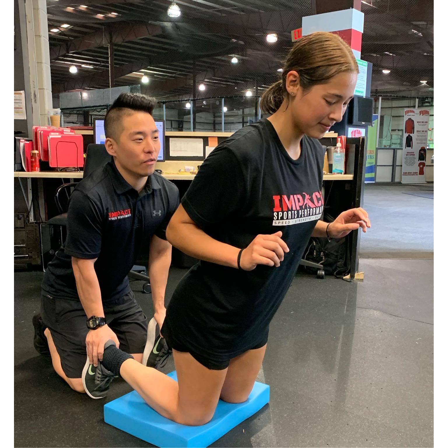 Athlete performing Nordic hamstring curls with coach support at Impact Sports Performance