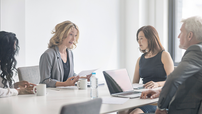 An advisory team meeting and reviewing documents.