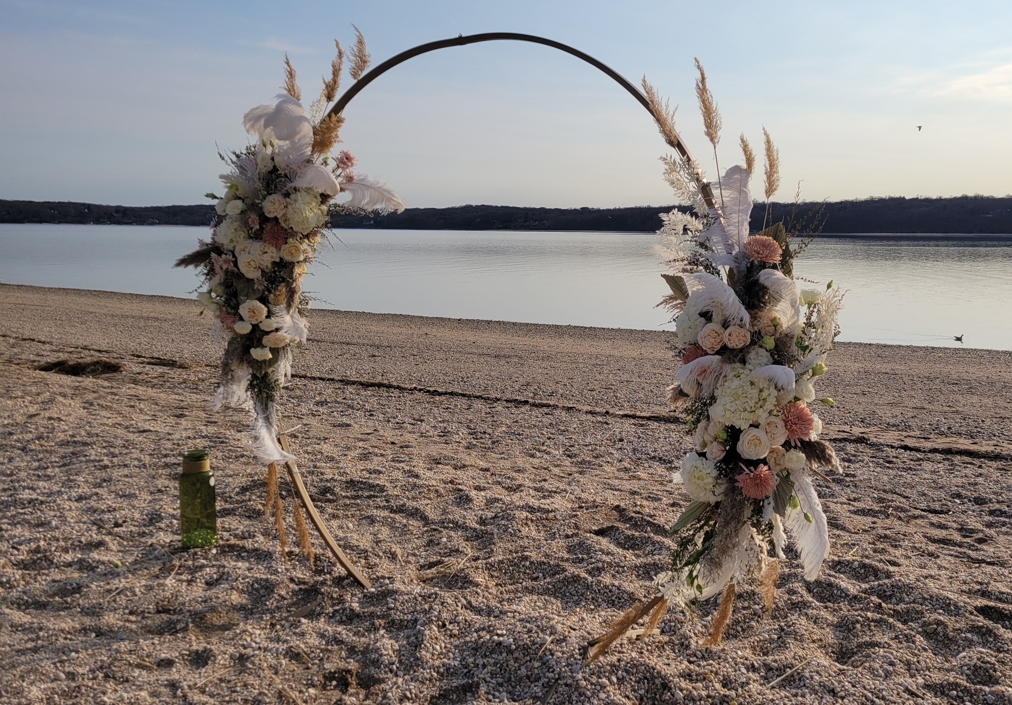 Boho wedding ceremony circle arch. West Neck Beach, Huntington NY. Neutral color palette with pampas grass, and ostrich feathers