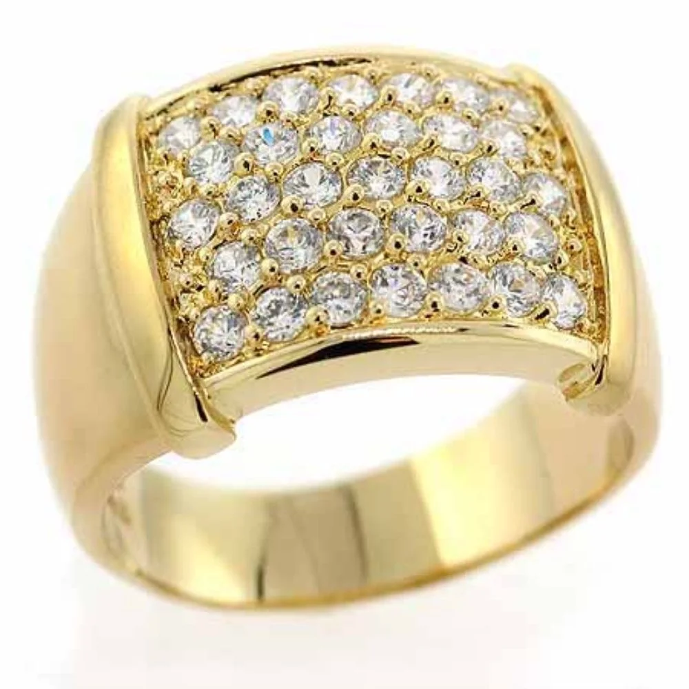 A close-up shot of a yellow gold ring encrusted with numerous small clear stones, likely diamonds or cubic zirconia, arranged in a pav&eacute; setting across a wide, rectangular face.