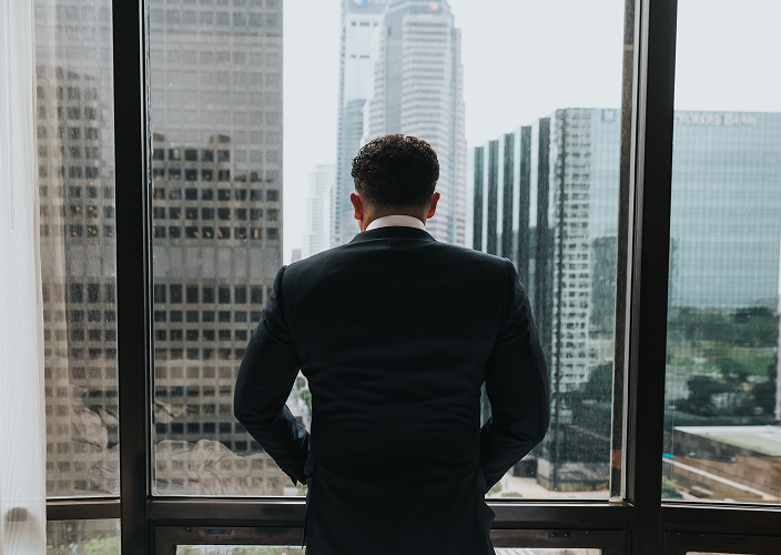 Professional looking out of the window of his office.