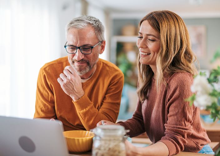 A couple reviewing their financial plan on their laptop.