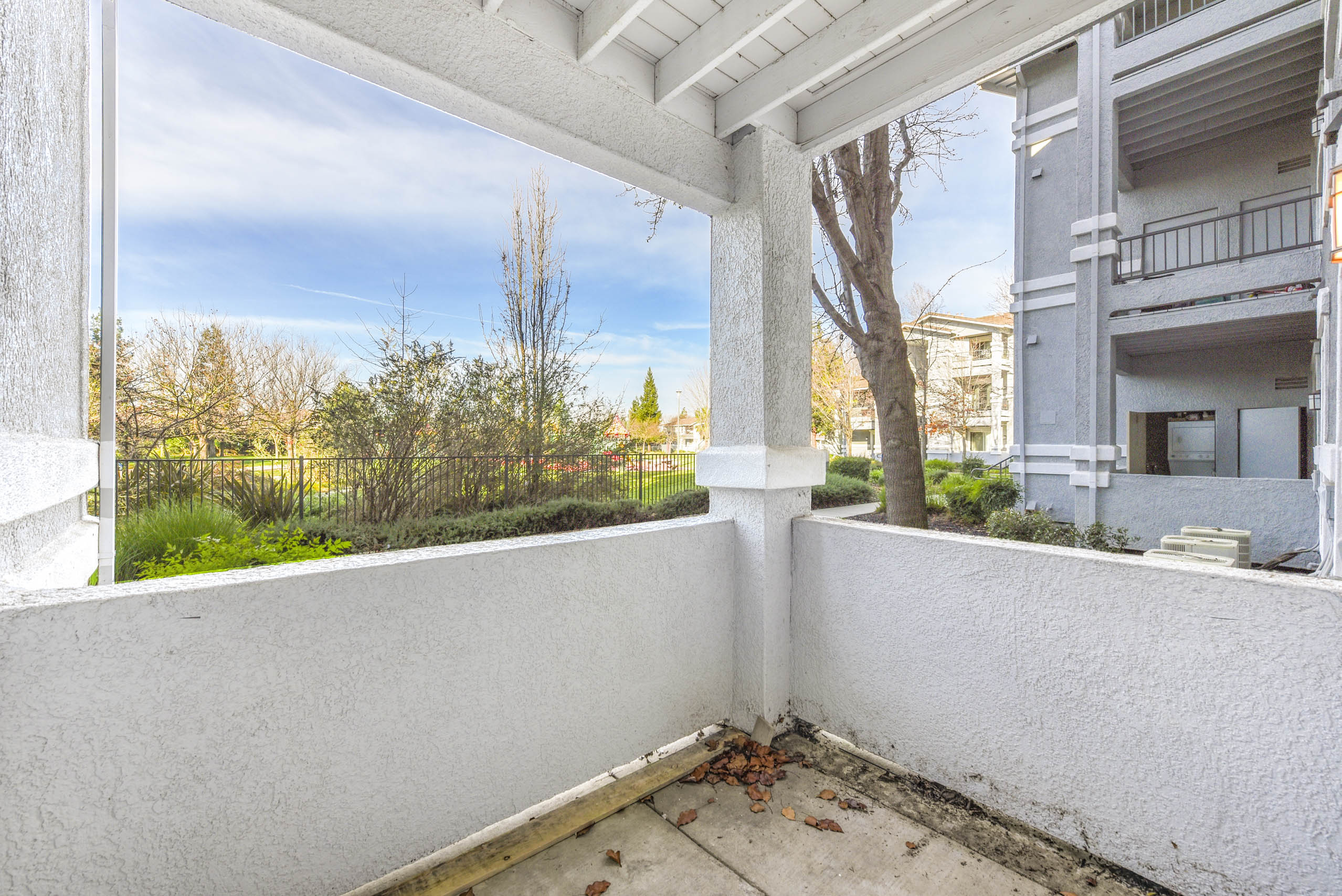 Covered patio corner overlooking grassy common area