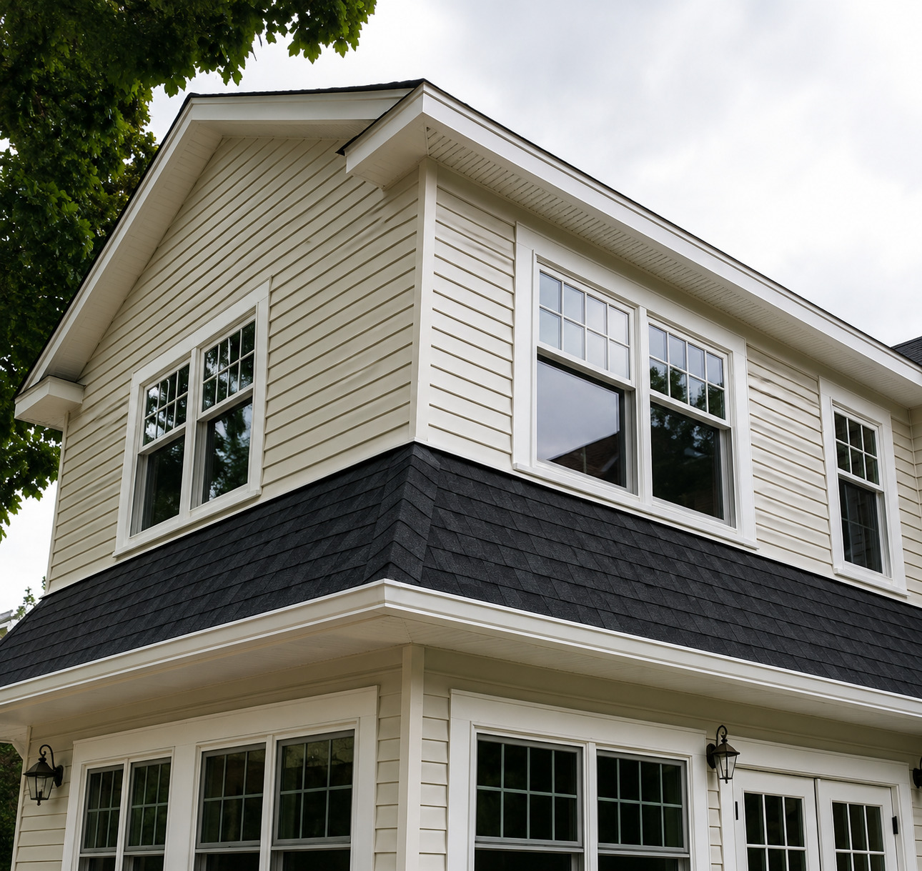 A two-story home showcases crisp white horizontal siding, large divided-light windows, black archite 