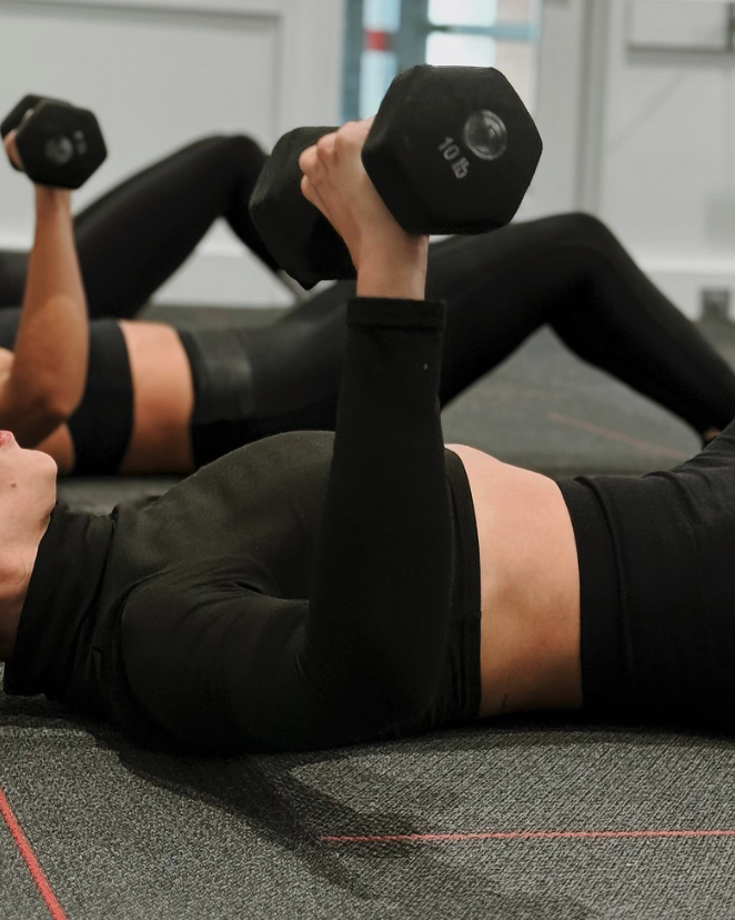 Pure Barre Define class in Aventura FL — member performing dumbbell strength training during a low-impact barre workout
