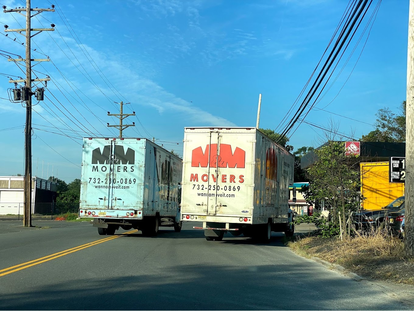 Two branded M&M Movers box trucks on the road, showing the company fleet ready for local and long-distance moves across New Jersey.