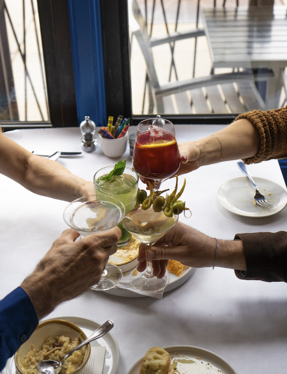 People at table with food and cocktails