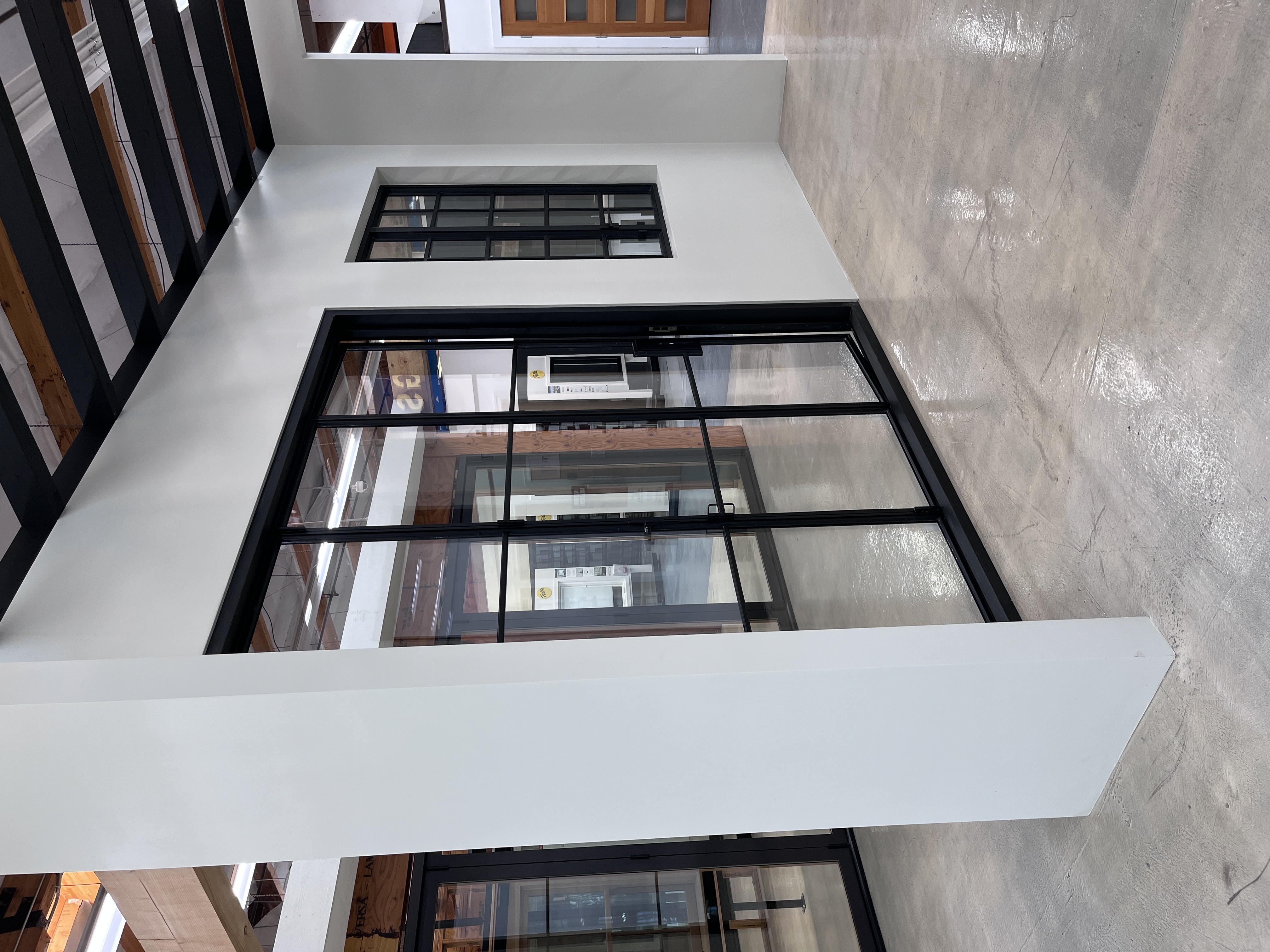 Interior showroom display of black-framed sliding glass doors and windows at Builders FirstSource Thousand Oaks, CA, set into a mock room structure.