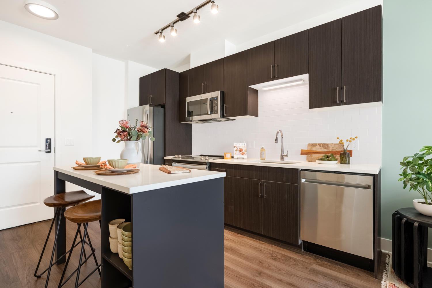 Glass tile backsplashes and quartz countertops brighten the kitchen.