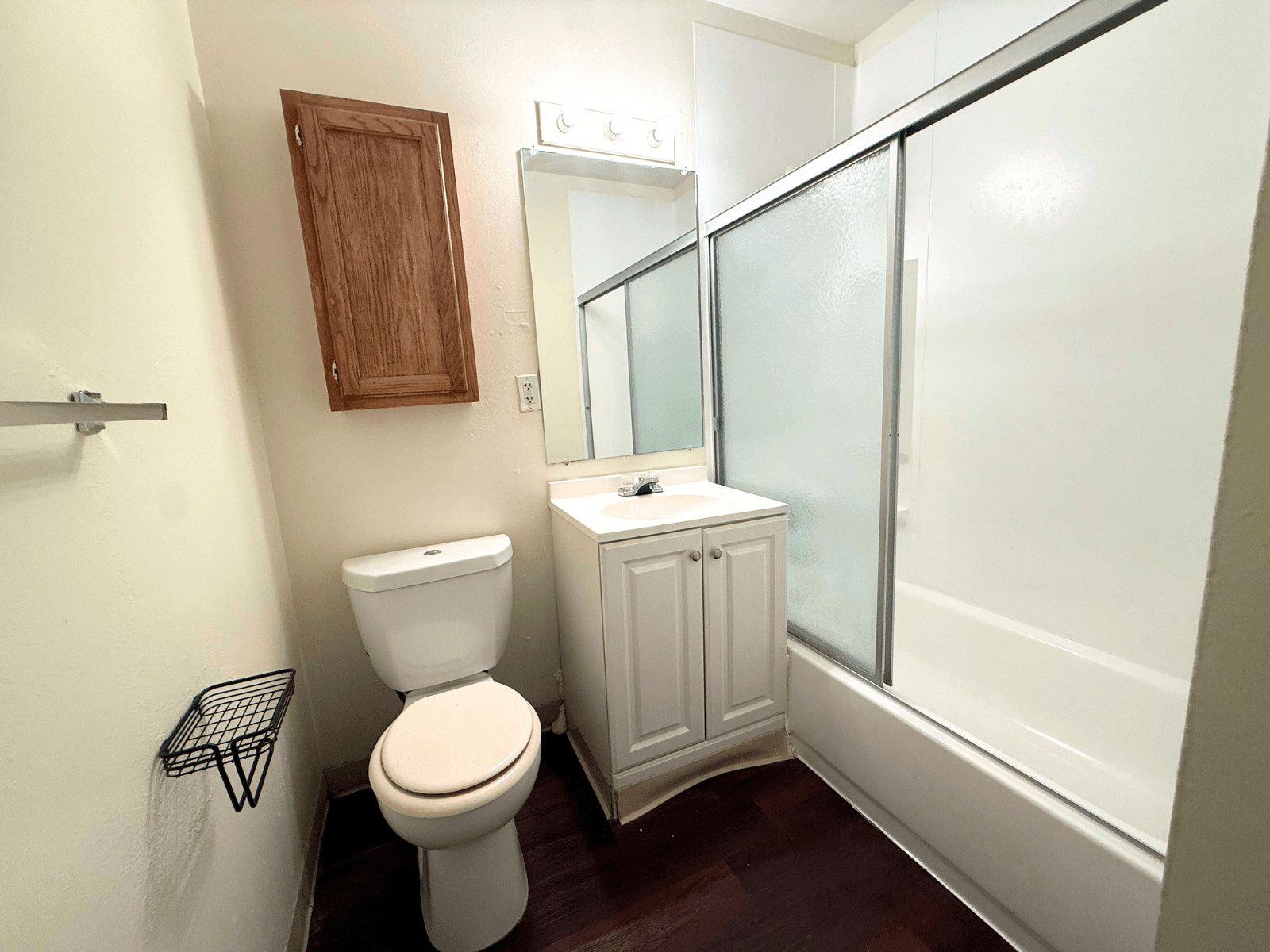 A white toilet sits next to a white sink in a small bathroom