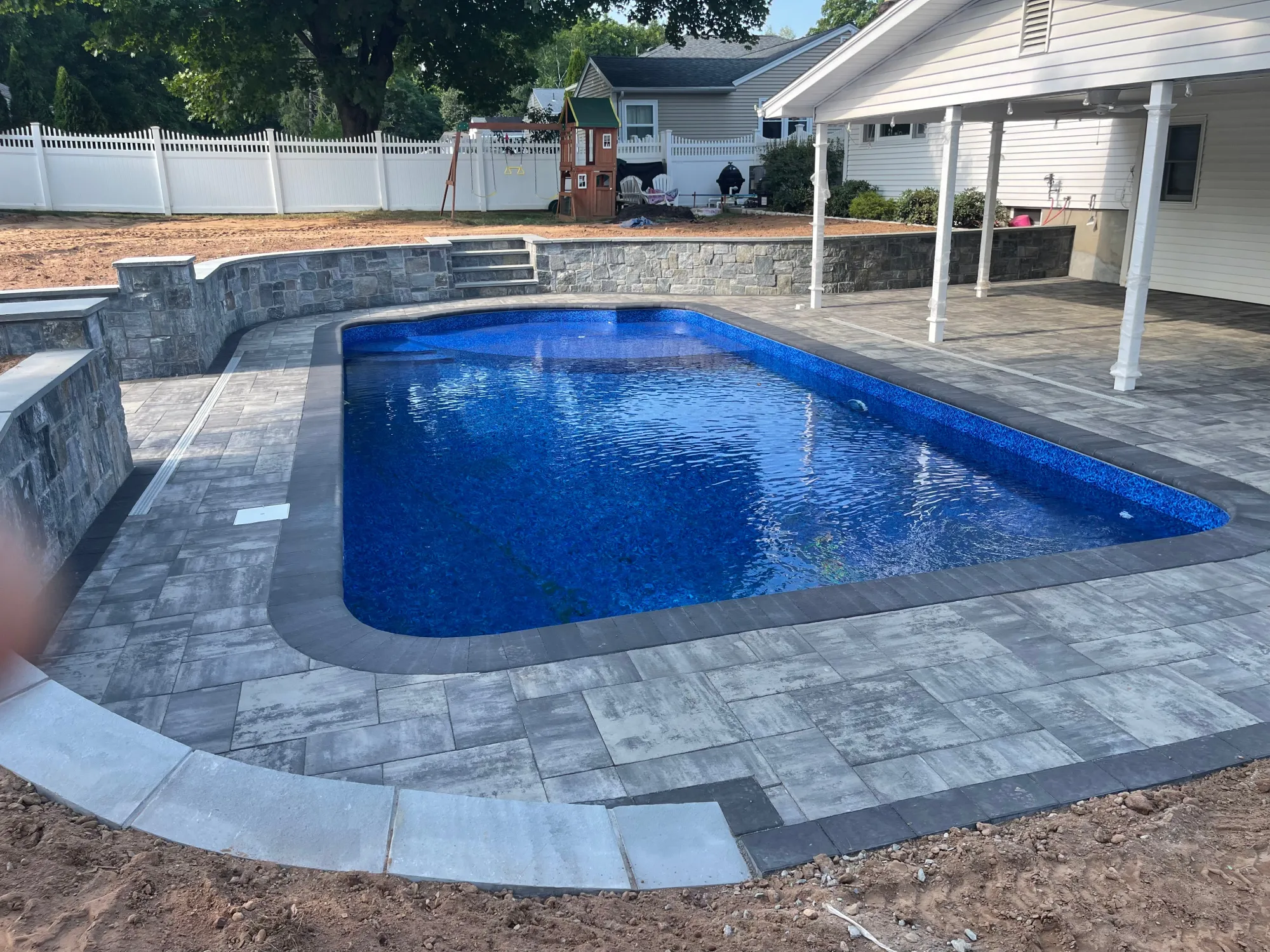Paver pool deck and coping around an in-ground pool - Paver Pool Decks project by General Masonry LLC.