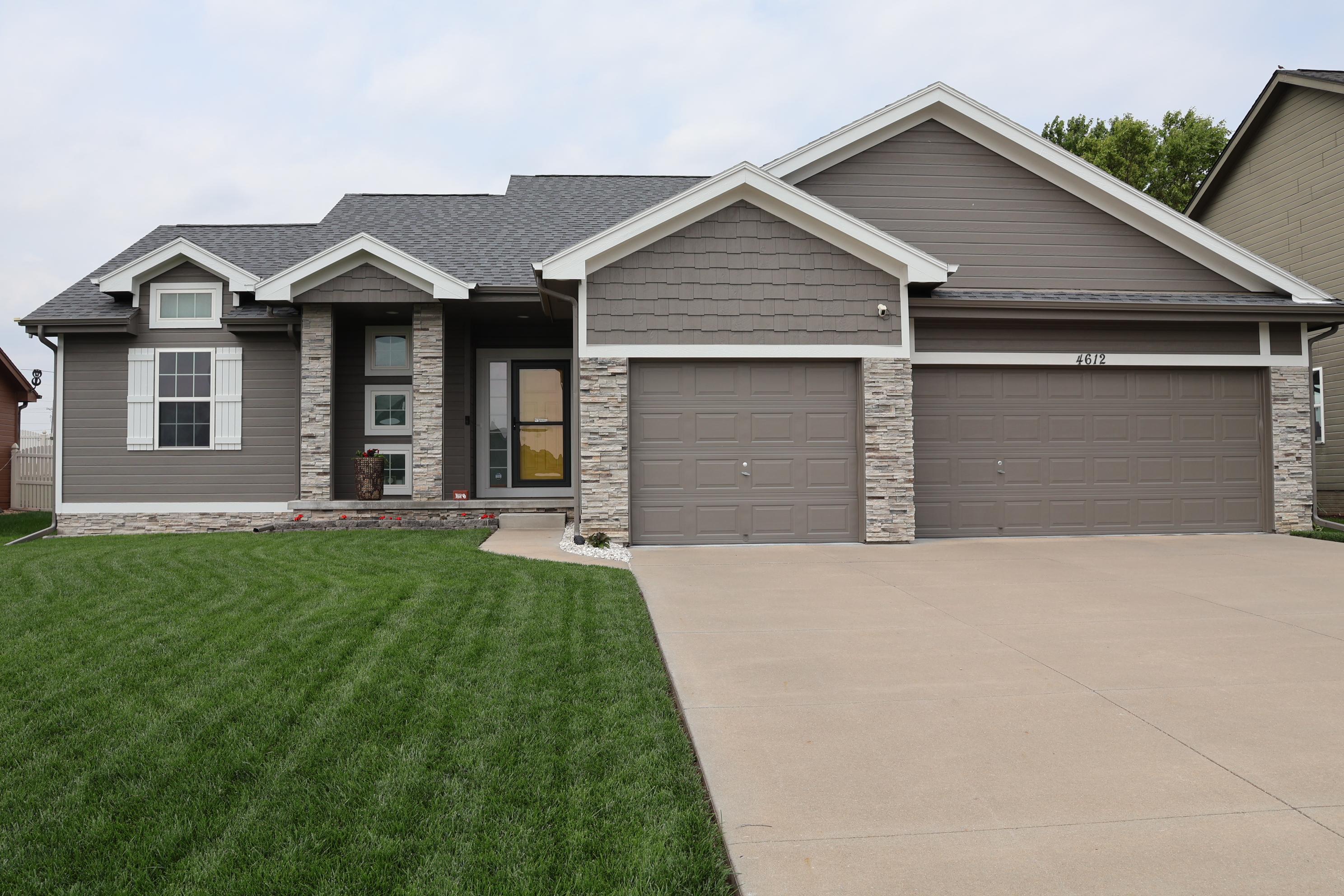 Freshly painted modern home in Omaha Nebraska with gray exterior siding and white trim by Scott&rsquo;s Painting & Staining Inc, professional exterior house painter