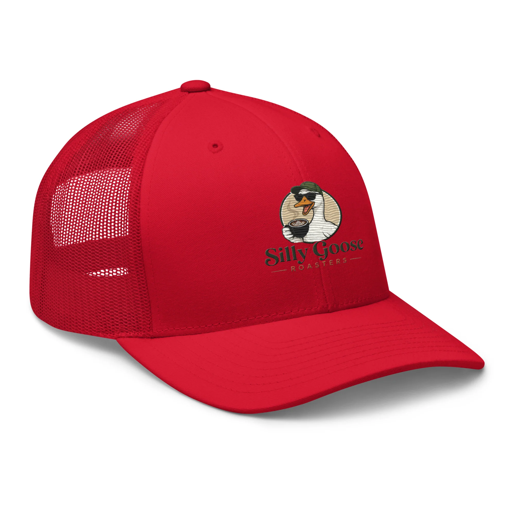 A bright red trucker hat with a mesh back is shown from a side-angled perspective against a white background. The hat features a circular logo embroidered on the front panel. The logo depicts a cartoon goose wearing sunglasses and a green cap, holding a cup of coffee with latte art. Below the goose illustration, the words "Silly Goose" are written in a stylized font, followed by "ROASTERS" in smaller capital letters, separated by dashes.