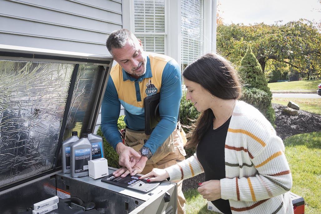 Thomas Edison Electric technician servicing a home backup generator and reviewing system controls with homeowner in Pennsylvania
