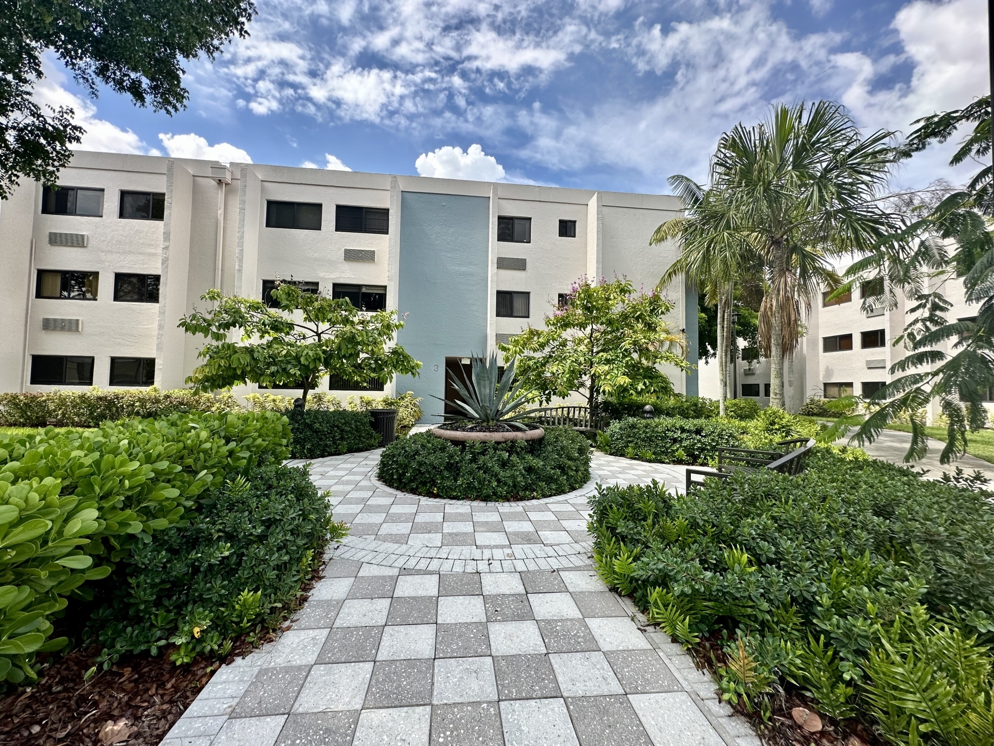 The Solaire At Las Palmas Village exterior with building, a patio and a garden