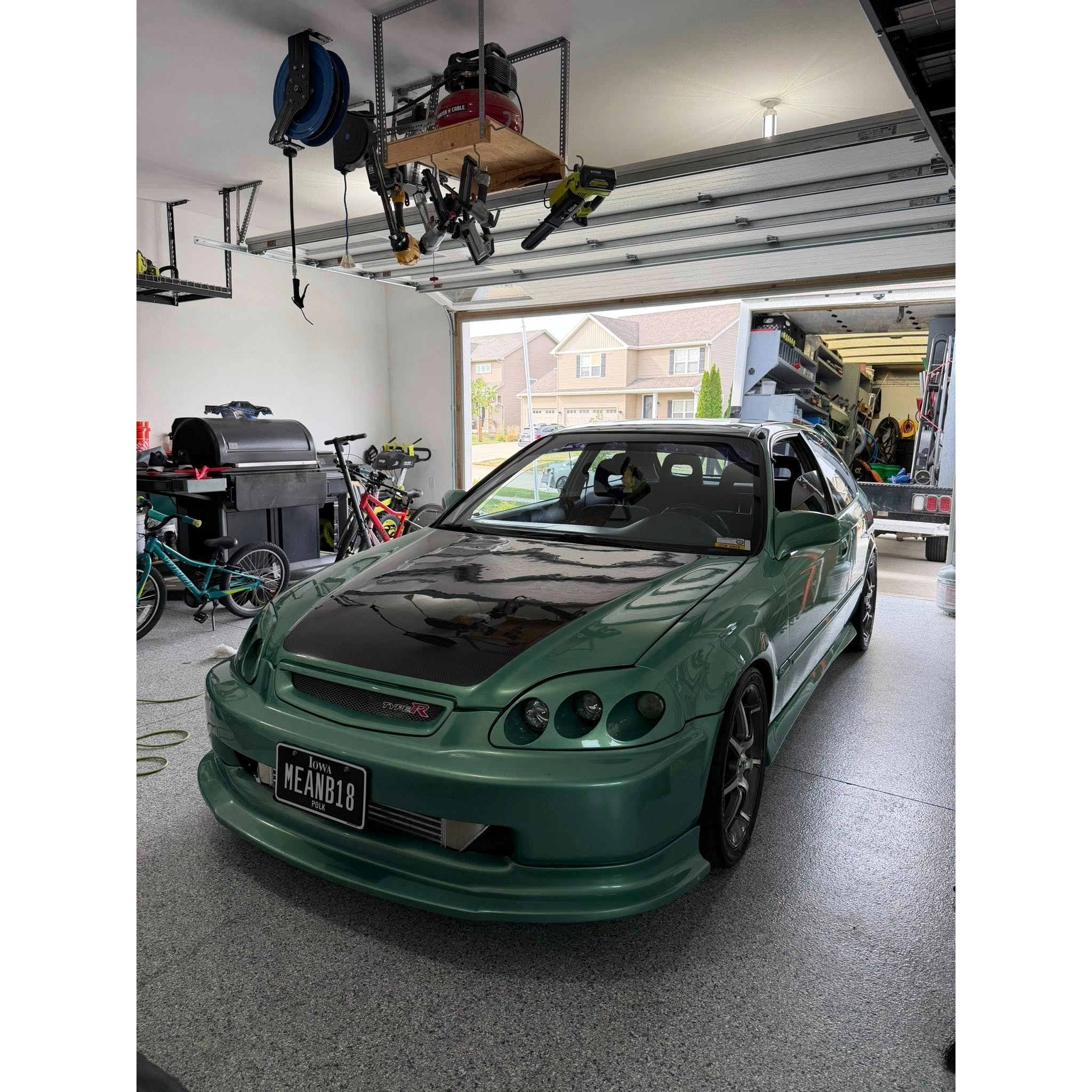 Professional mobile auto detailing photo showing a freshly cleaned green sports coupe with a glossy exterior finish, detailed wheels, and clean presentation for AMT Mobile Detailing in the Des Moines area.