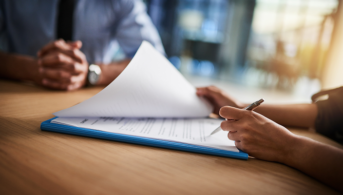 Close up of a client signing a document.