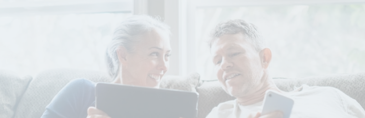 A couple on their couch looking at their devices.