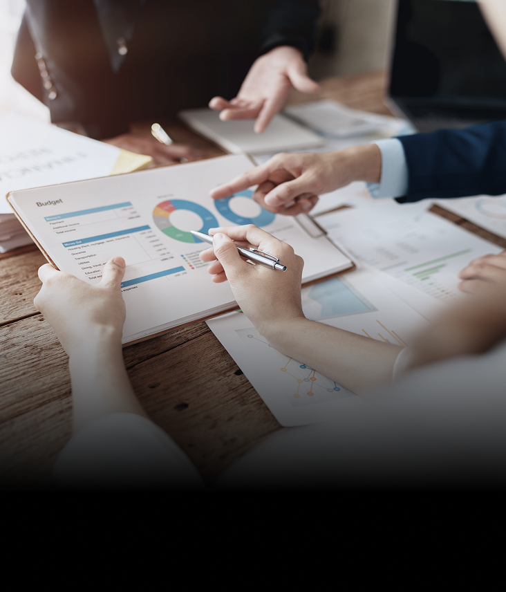 Close-up shot of a client and advisors reviewing documents on a clipboard.