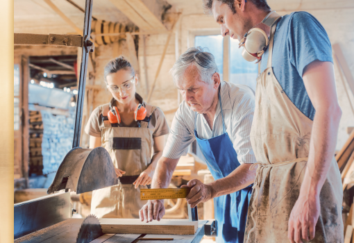 Three people working in a woodshop.