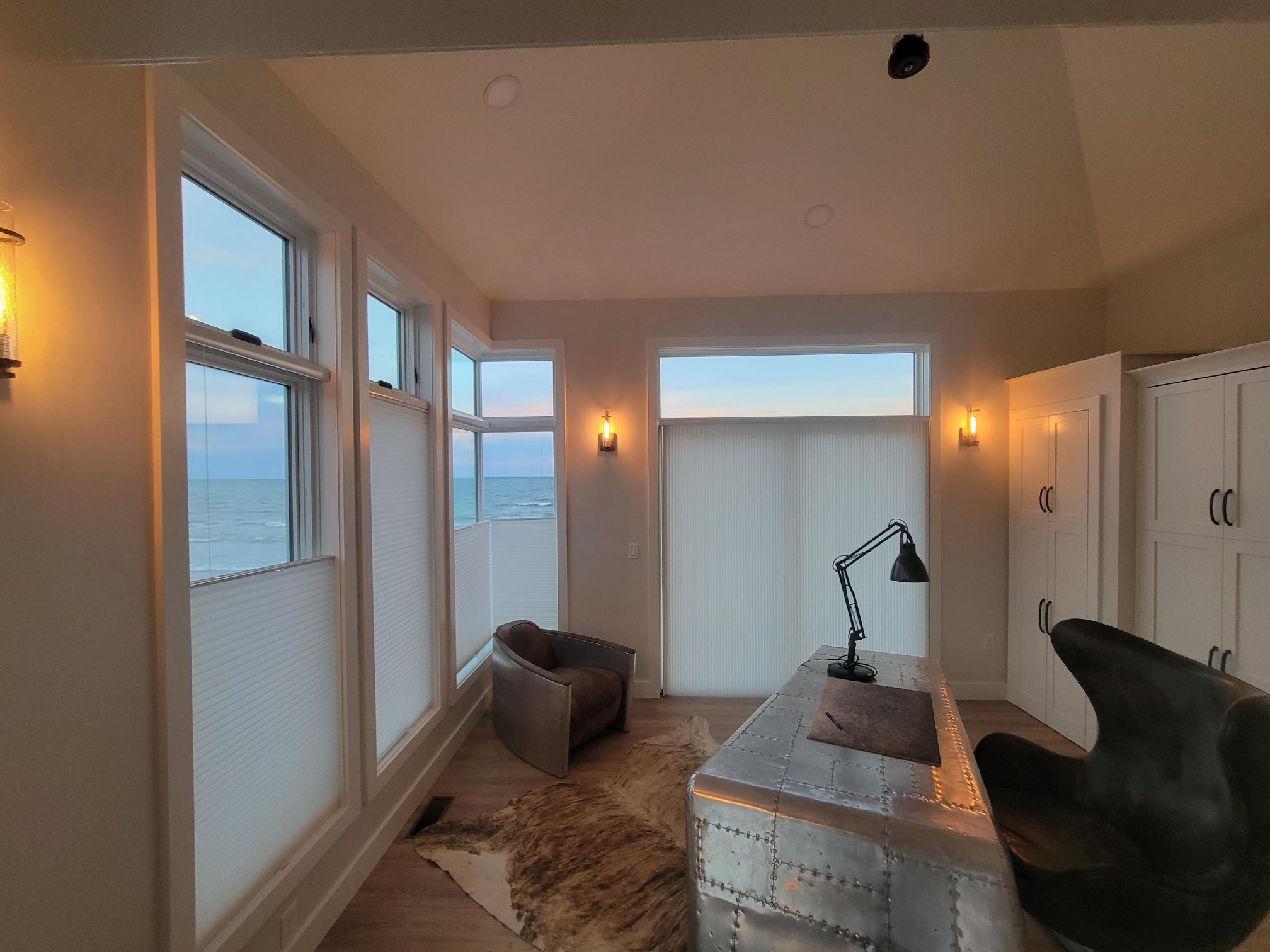 Maximize privacy and your lake view - these motorized honeycomb shades let in light from the top while keeping the bottom covered. The perfect balance for any modern coastal office!