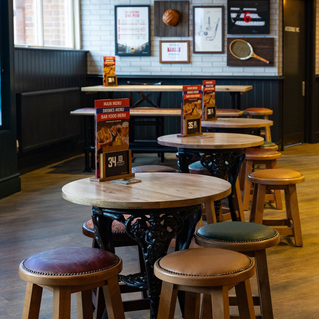 Modern seating area with high tables and stools, perfect for quick drinks or casual catch-ups.