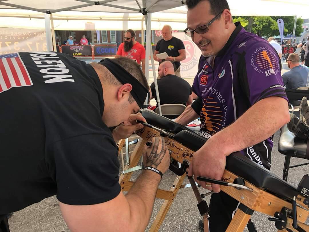 World strongest and competitor and Giants live Champion Evan Singleton signs his autograph alongside some of greatest champions strongmen on Dr. McDougle's chiropractic table.