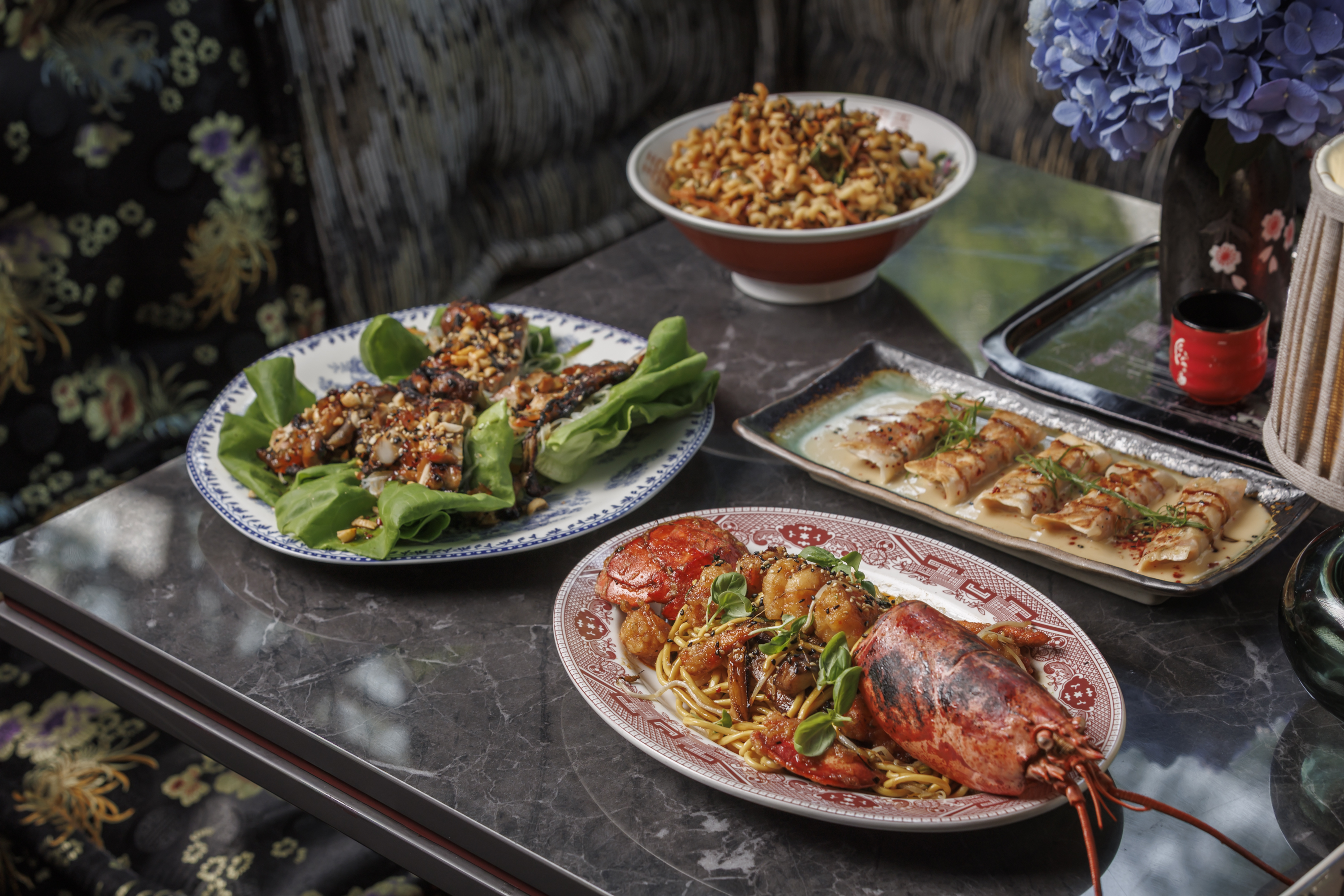 A selection of signature Mr. H dishes in Boston's Seaport District, featuring Ginger Scallion Lobste 