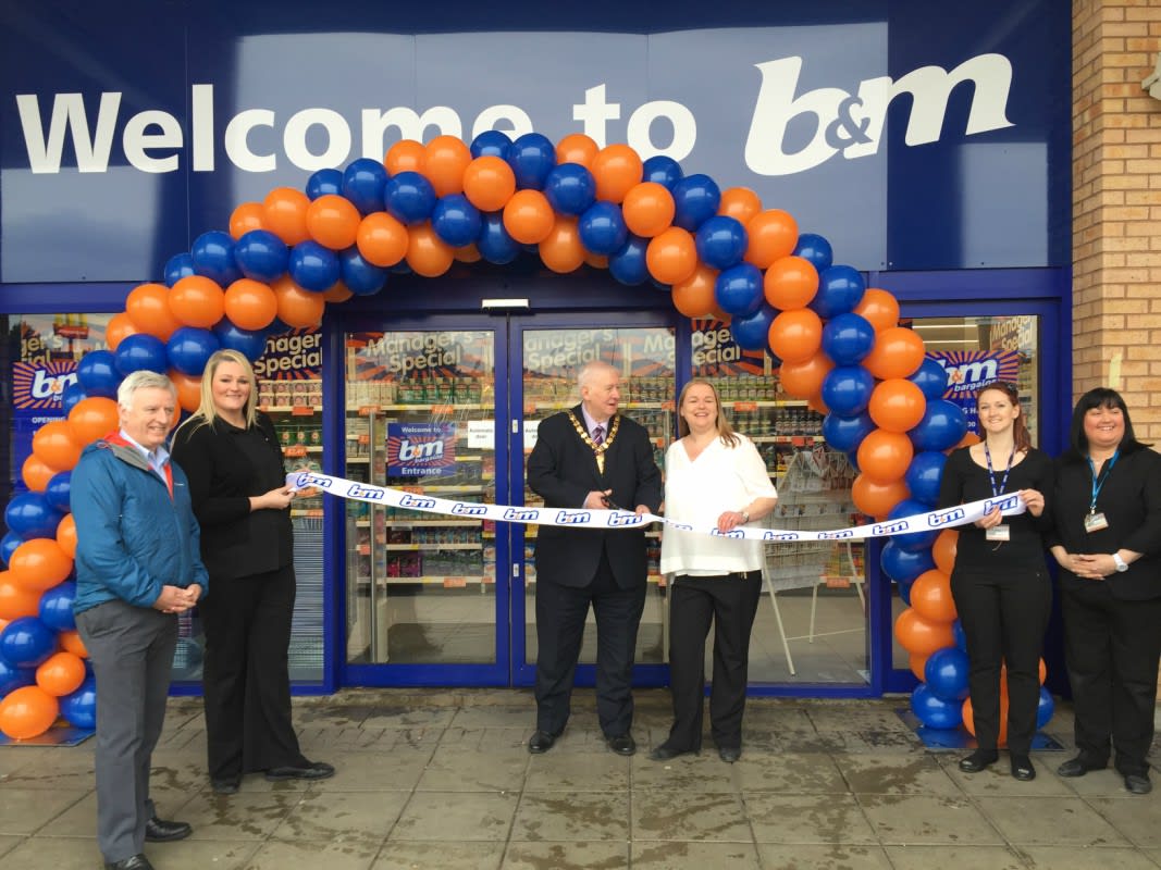Lord Provost James Robertson joins Booby Mason from St Andrew's Hospice charity to cut the ribbon and officially re-open B&M Airdrie Retail Park store
