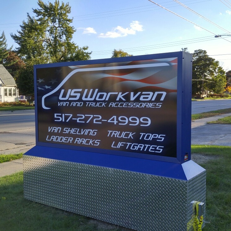 US Workvan sign featuring the company logo, phone number, and a list of van and truck accessories they sell and install