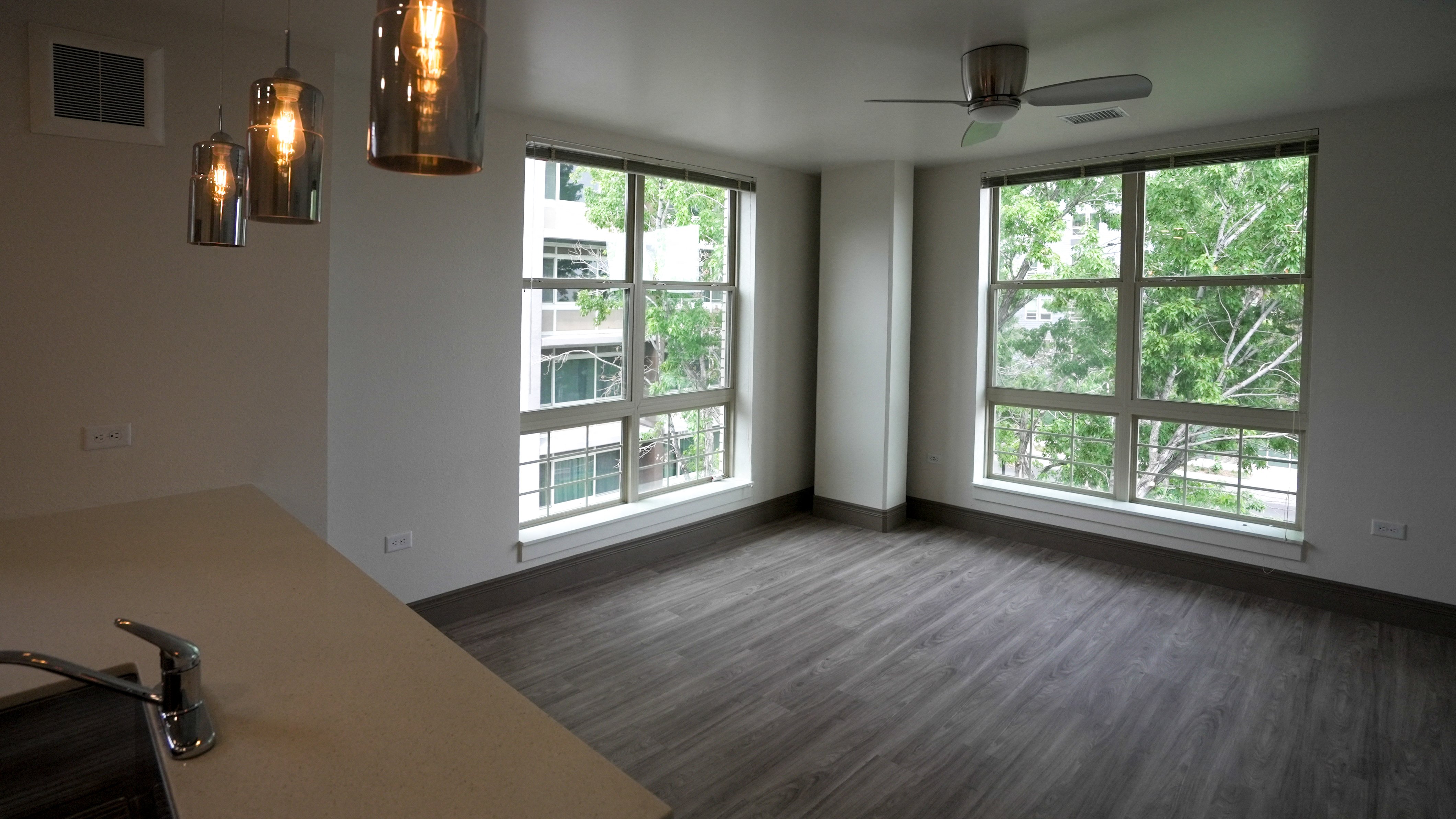 A room with a table, chairs, and a window overlooking a tree-filled area