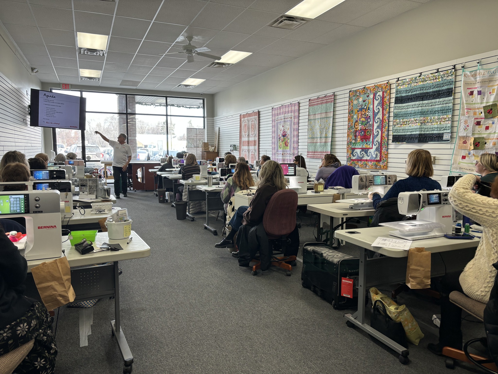 Students participate in a Decorative Stitch quilting class, following live instruction while learning decorative stitch techniques on Bernina sewing machines. A fun, hands-on workshop for quilters of all skill levels.