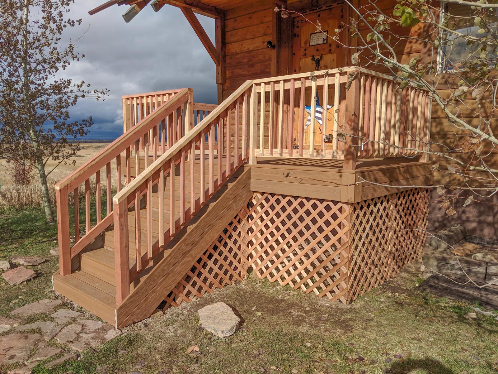 Achieve the perfect blend of rustic charm and modern durability with this custom DeckPro LLC project. We paired low-maintenance brown composite decking with natural wood railings and matching lattice skirting to seamlessly complement the style of this country cabin.