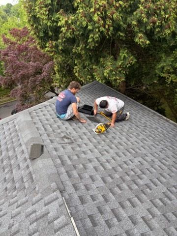 Roofing professionals inspect and assess an asphalt shingle roof for maintenance or repair needs. Ca 