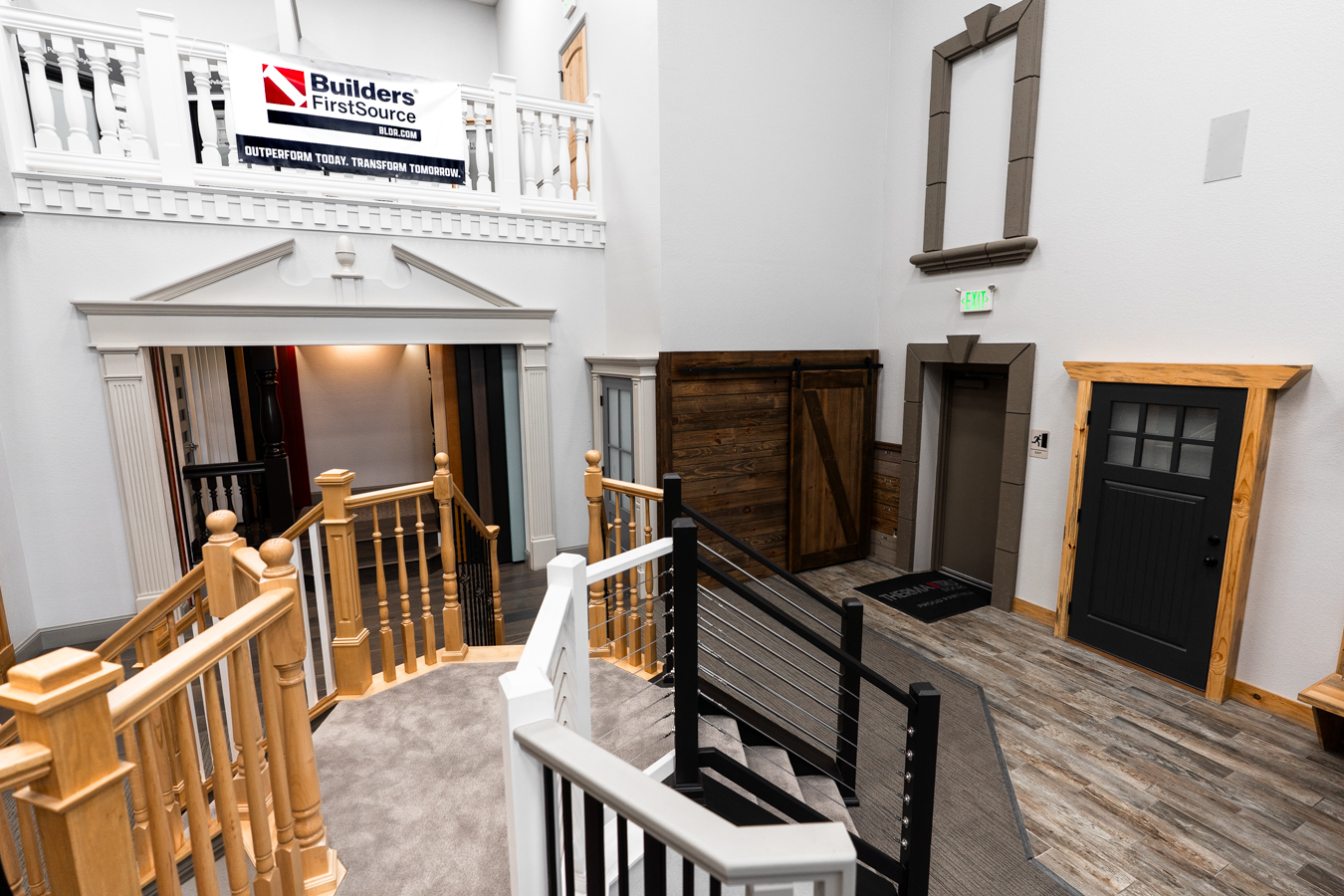 Builders FirstSource showroom with diverse railing styles, wood accents, and doors, showcasing construction materials and design.