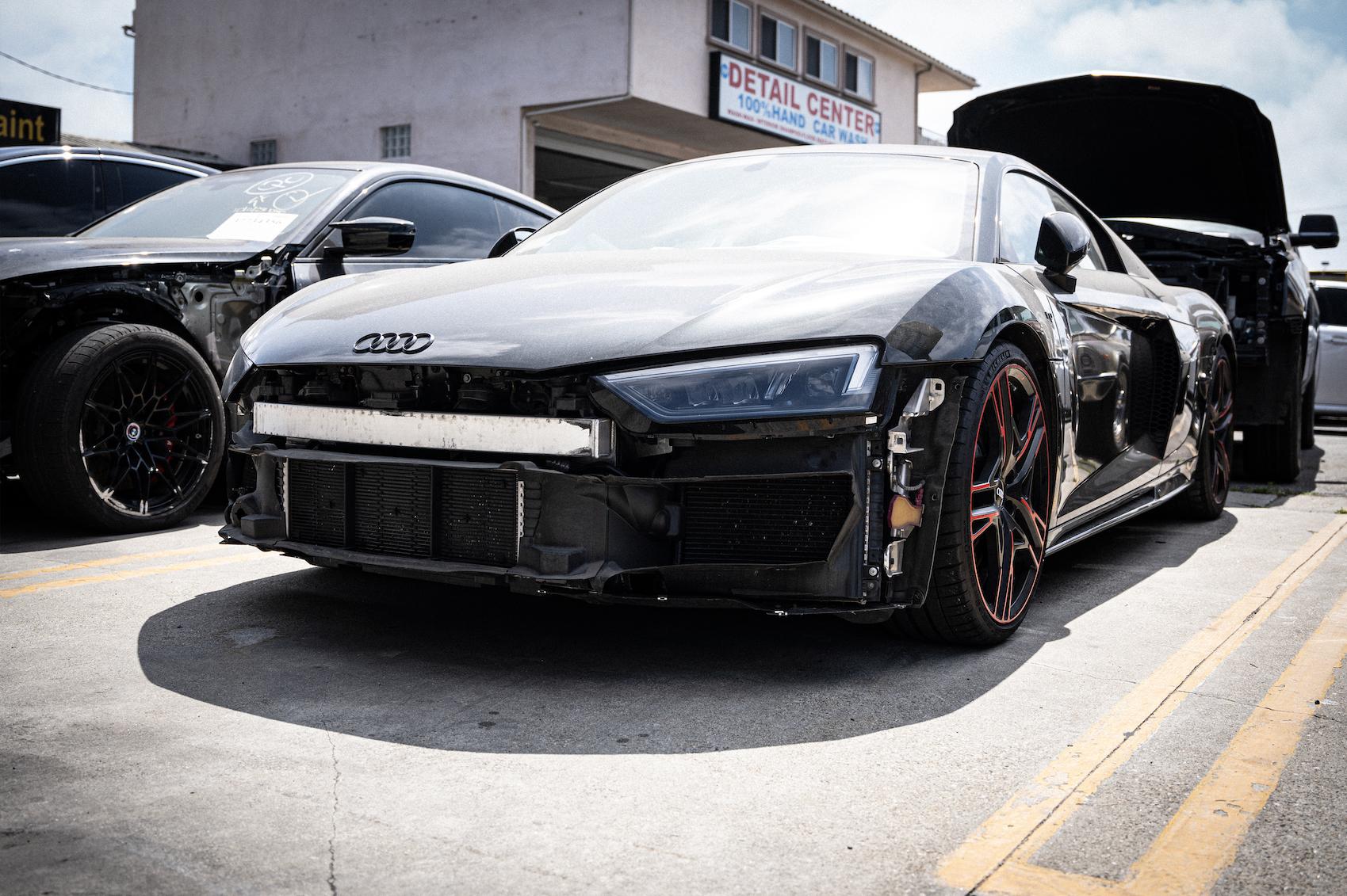 Detailed photo of Audi R8 waiting at auto body shop parking lot for collision repair