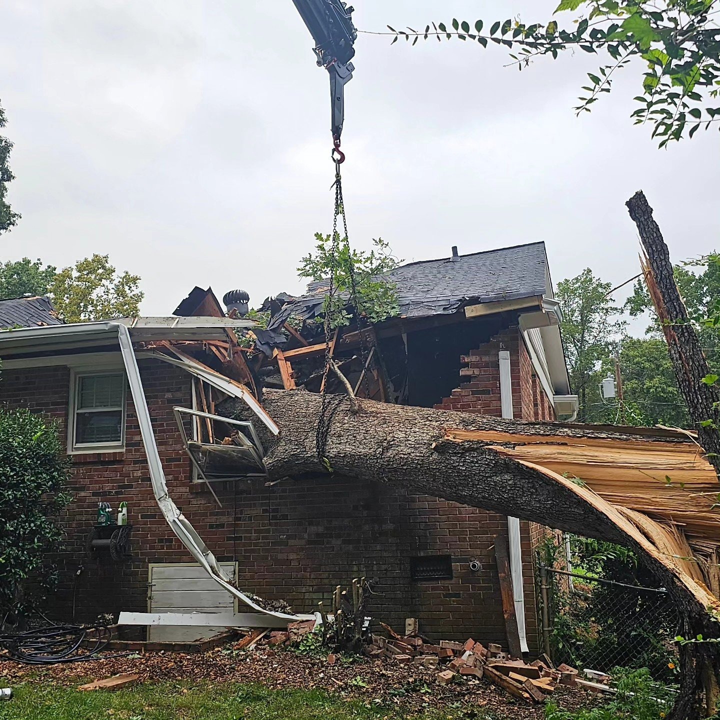 Emergency removal of a storm-damaged tree that fell on a house