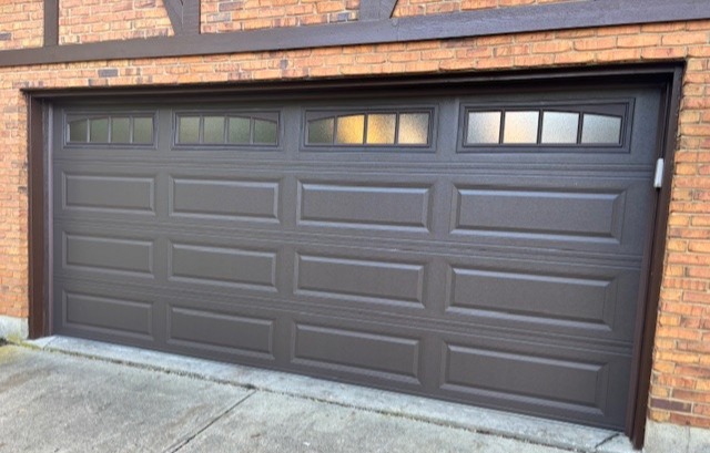 Residential sectional garage door with raised panels and top-row windows, installed by Highfield Door Sales in Springboro, Ohio. This design adds natural light while maintaining durability, security, and strong curb appeal to match house details.