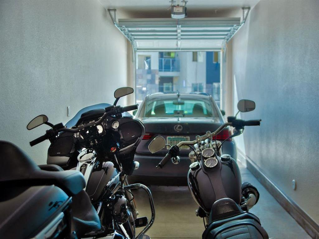 apartment garage showing two motorcycles in the foreground and Car