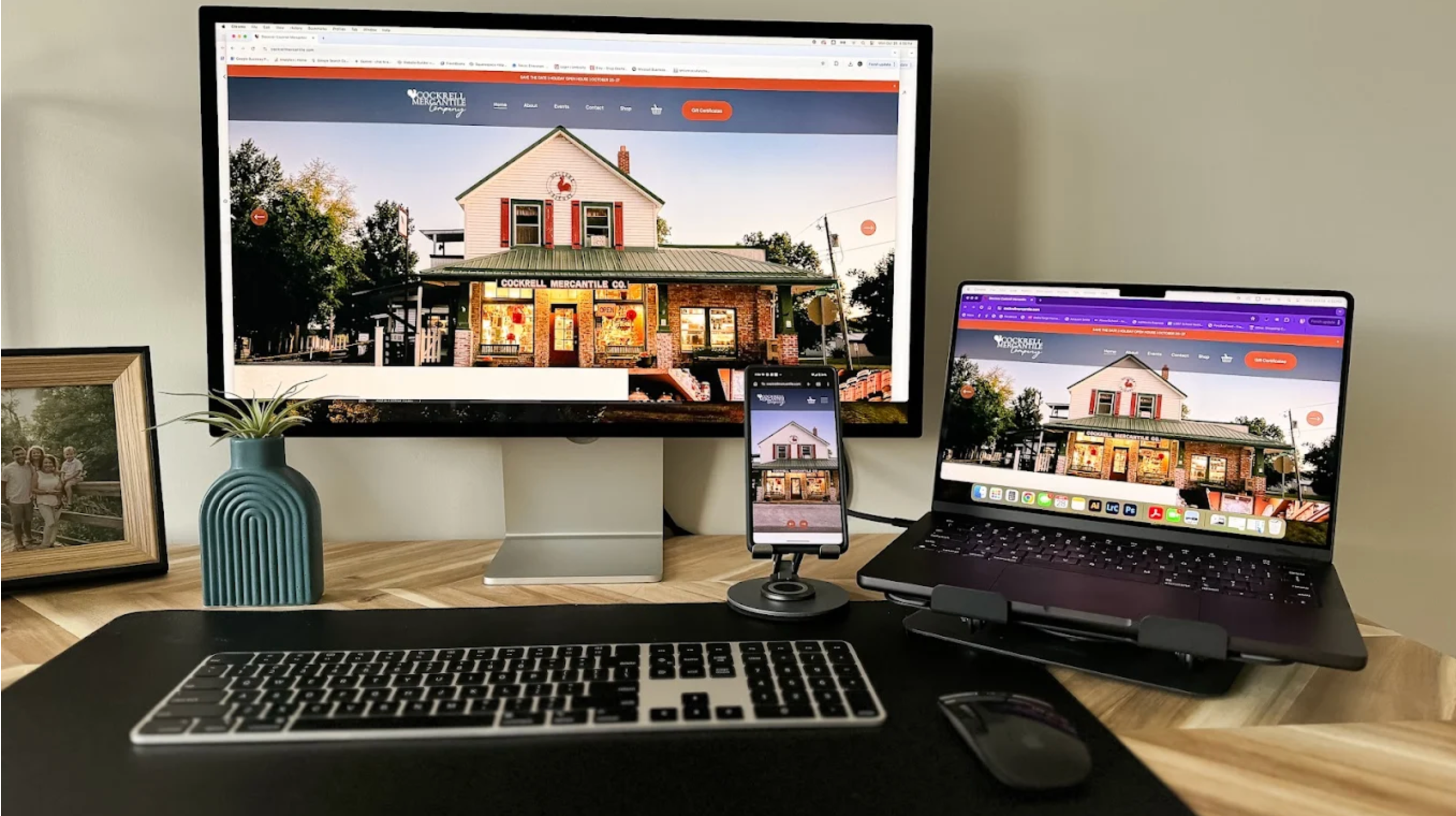 Photo of a workspace showing a business website displayed on a desktop monitor, laptop, and smartphone to illustrate responsive web design.